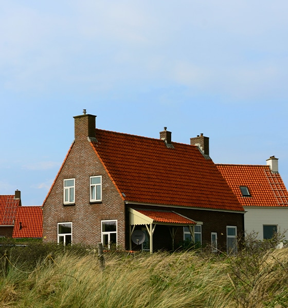 Karakteristieke woning in de duinen met Texelse vuurtoren