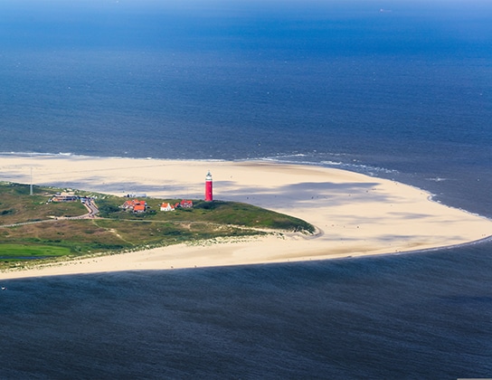 Luchtfoto van de vuurtoren van Texel bij het strand en de Noordzee