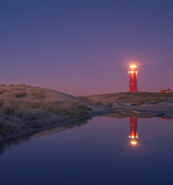 Vuurtoren van Texel bij schemering met reflectie in het water