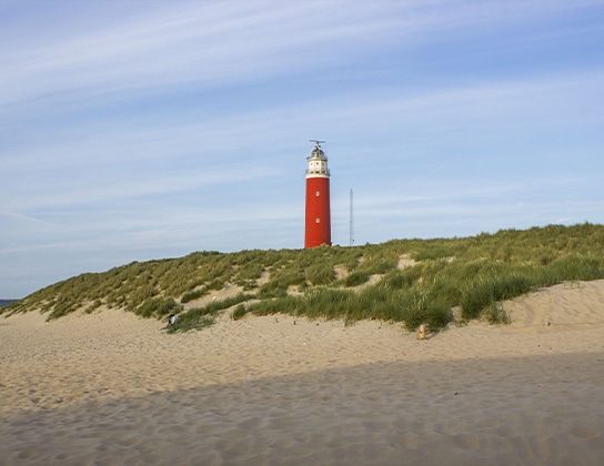 Rode vuurtoren van Texel boven de duinen aan het strand bij De Cocksdorp