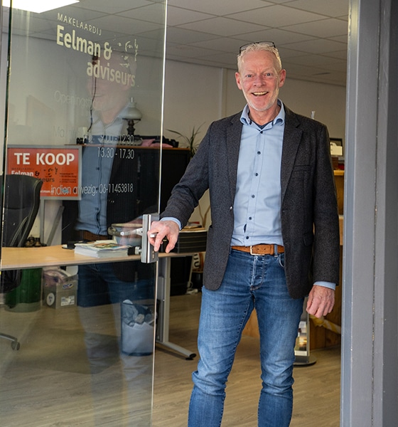Makelaar van Makelaardij Eelman bij de entree van het kantoor op Texel
