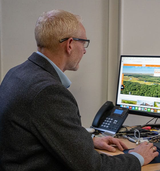 Makelaar van Makelaardij Eelman bekijkt online woningaanbod op kantoor in Den Burg Texel